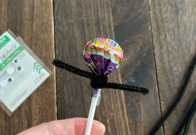 棒キャンディに黒いモールを巻き付けているところ