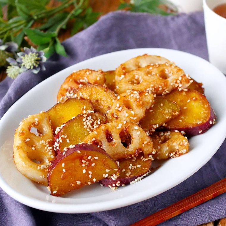 白い楕円型の皿に盛り付けたさつまいもとれんこんのバタポン炒め