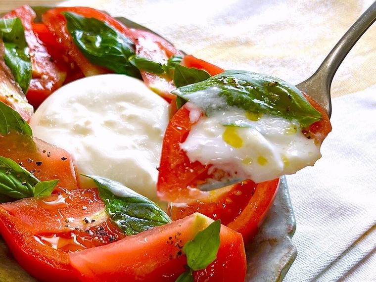 業務スーパーの冷凍ブッラータチーズで作ったカプレーゼをフォークですくった様子