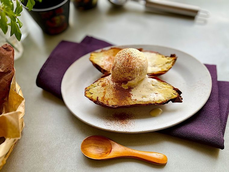 半分にカットして上にアイスとシナモンパウダーをトッピングしたコストコの焼き芋、グレーの皿、木製のカトラリー、紫のナプキン