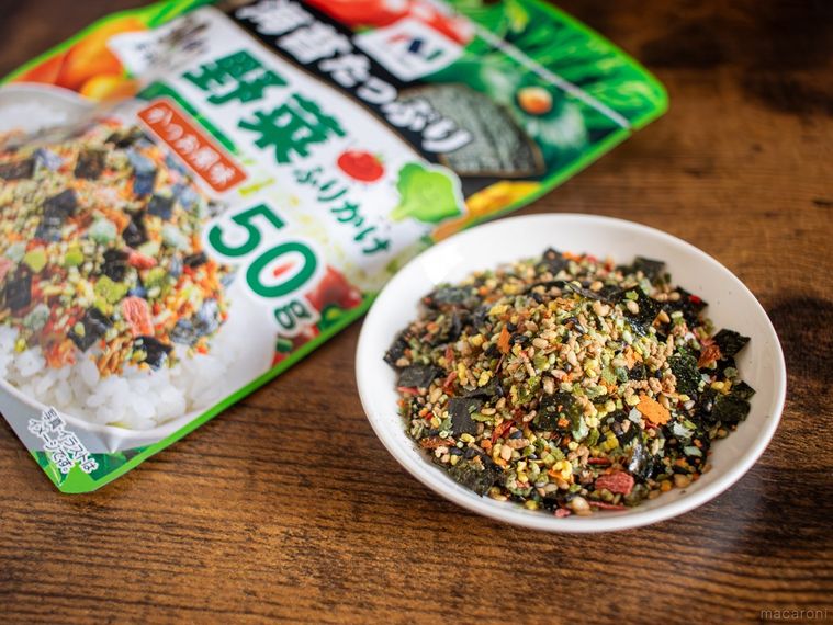 木製のテーブルにニコニコのり30種の素材が入った 野菜ふりかけのパッケージと小皿に盛った中身が並んでいる