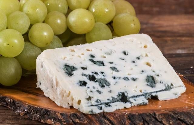 木のボードに置かれたブルーチーズとシャインマスカット