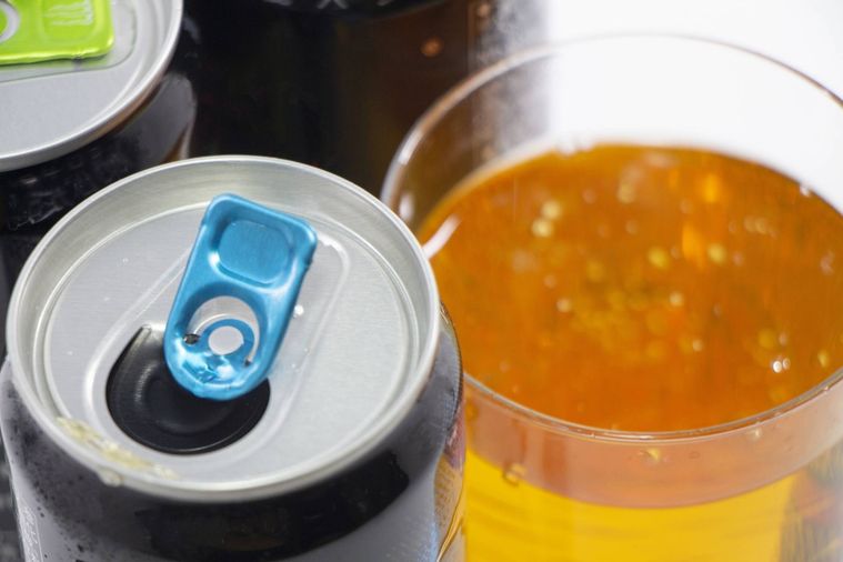 グラスに入ったエナジードリンクとエナジードリンクの缶