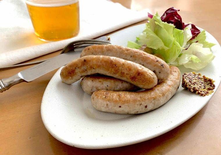サラダとマスタードが添えられたソーセージ