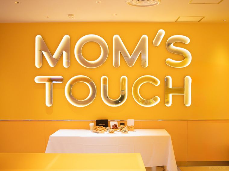 マムズタッチの壁面と試食メニューが並んだテーブル