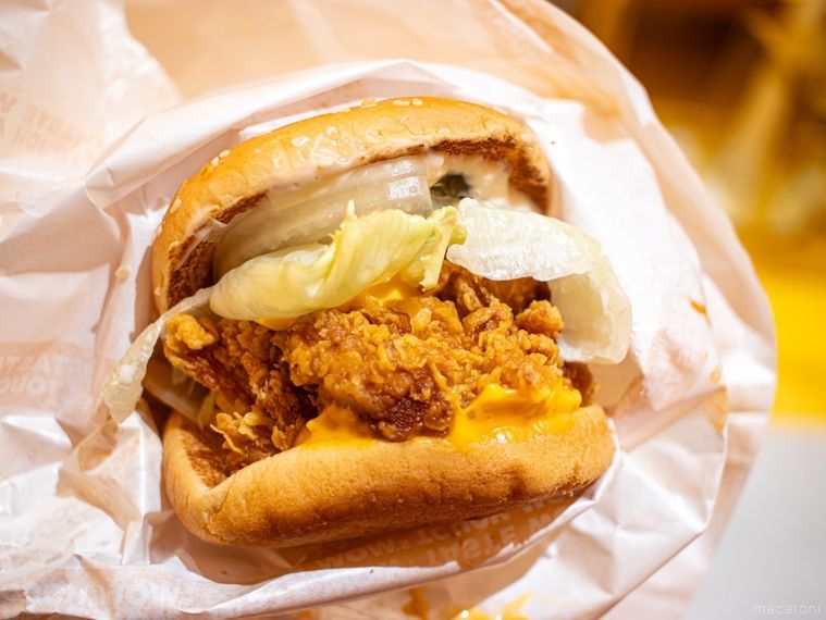 マムズタッチチーズサイバーガーを手で持っている