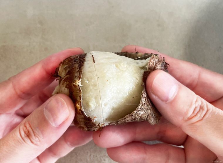 里芋をゆでたあとに皮を手で剥いている写真