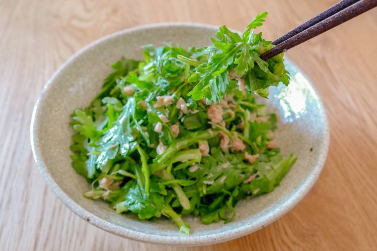 春菊とツナのサラダを箸でつまみ上げる様子