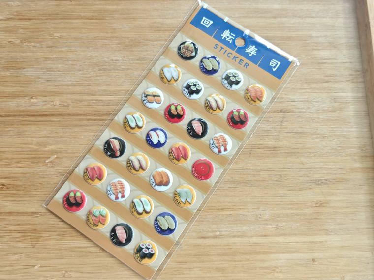 回転寿司 STICKERが机の上に置いてある