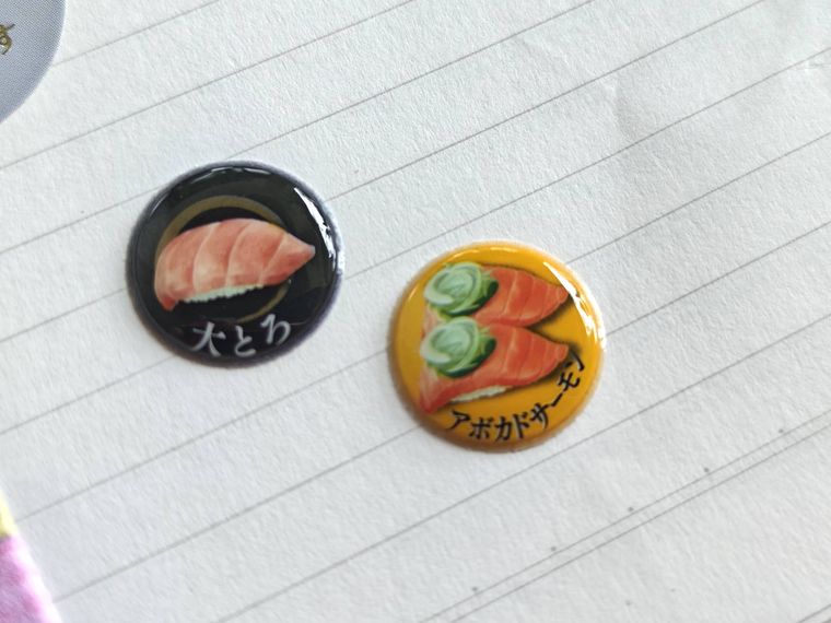 回転寿司 STICKERをノートに貼っている様子