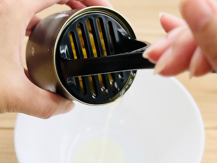 ダイソーのナイロンミニマッシャーでコーン缶の汁気を切っている様子