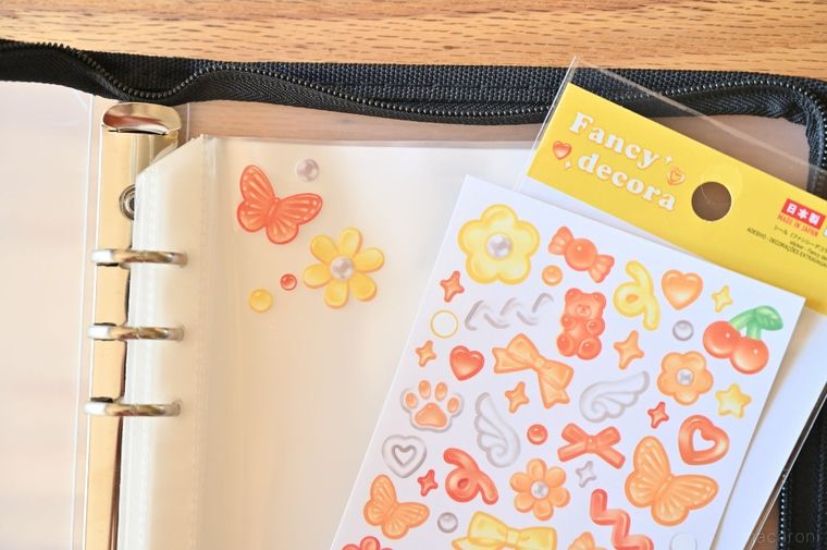 ダイソーファンシーデコラと数枚のシールを貼ったシール帳