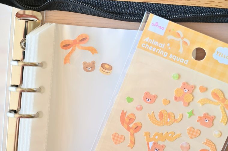 ダイソーシートシールアニマル応援団と複数のシールを貼ったシール帳