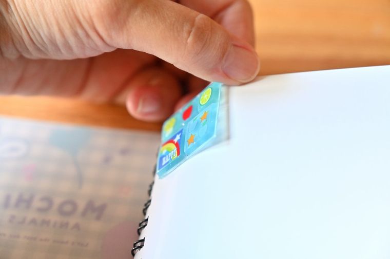 シール帳に貼ったタイルシールを剥がそうとしている