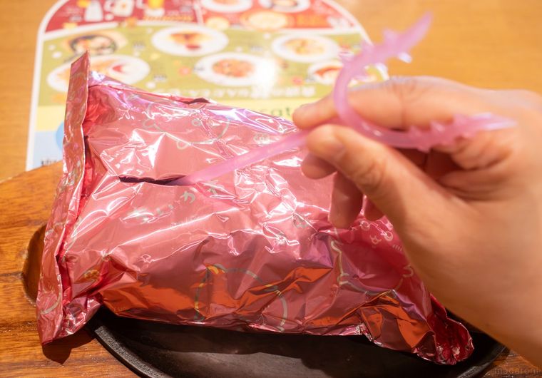 さすまた風ホイルカッターでちいかわのトマトクリーム包み焼きハンバーグのアルミホイルを破いている