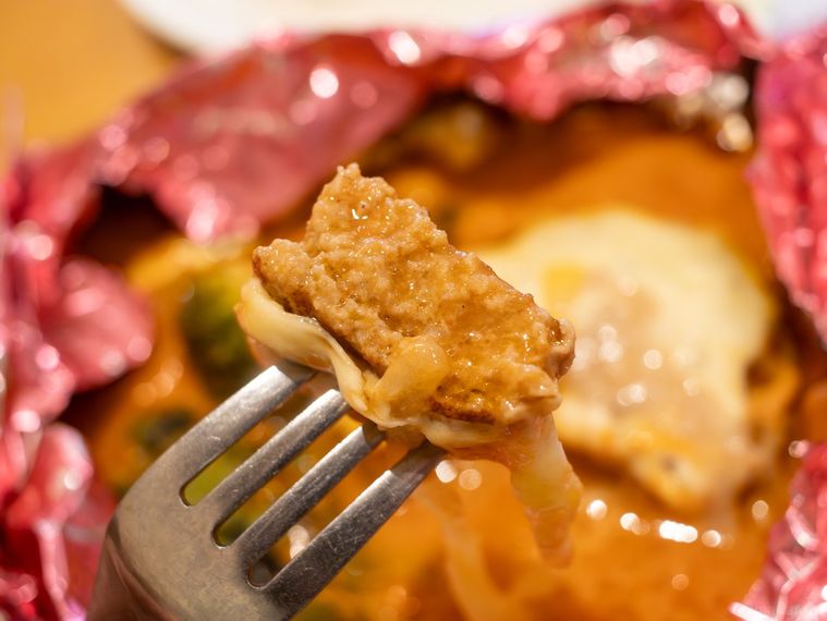 ちいかわのトマトクリーム包み焼きハンバーグのハンバーグをひと口サイズに切ってフォークで持ち上げた様子