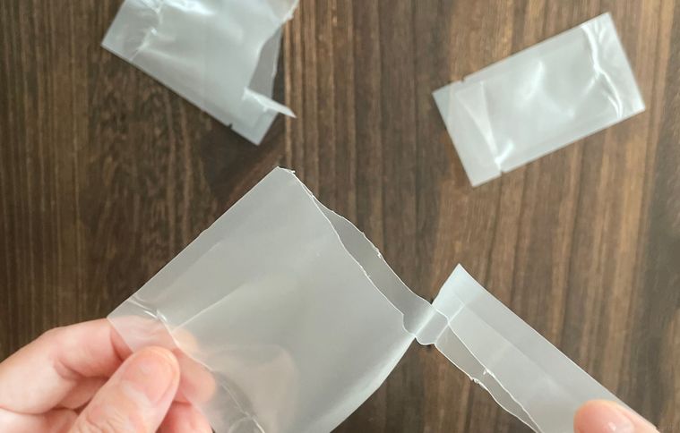 熱圧着パウチを手で開封しているところ