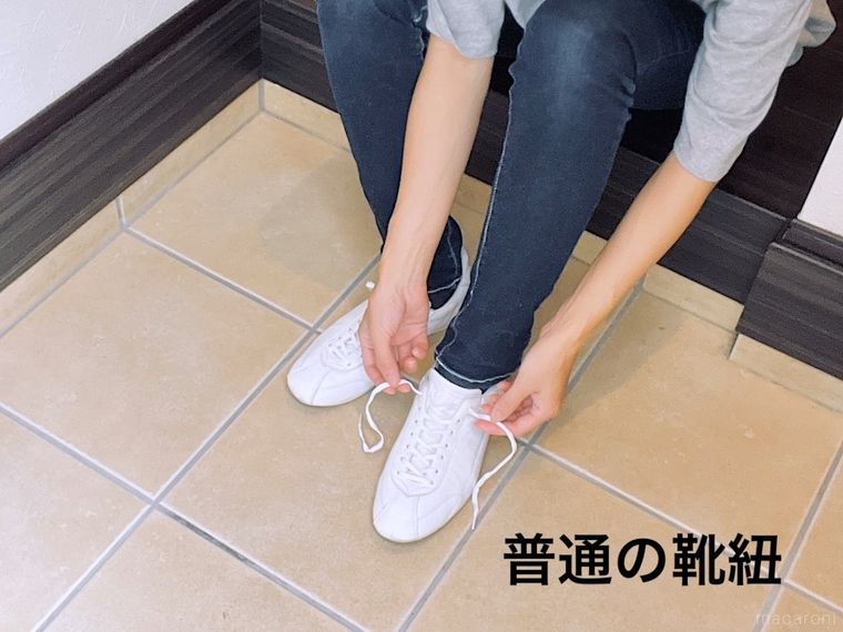 座って白いスニーカーを履いている様子