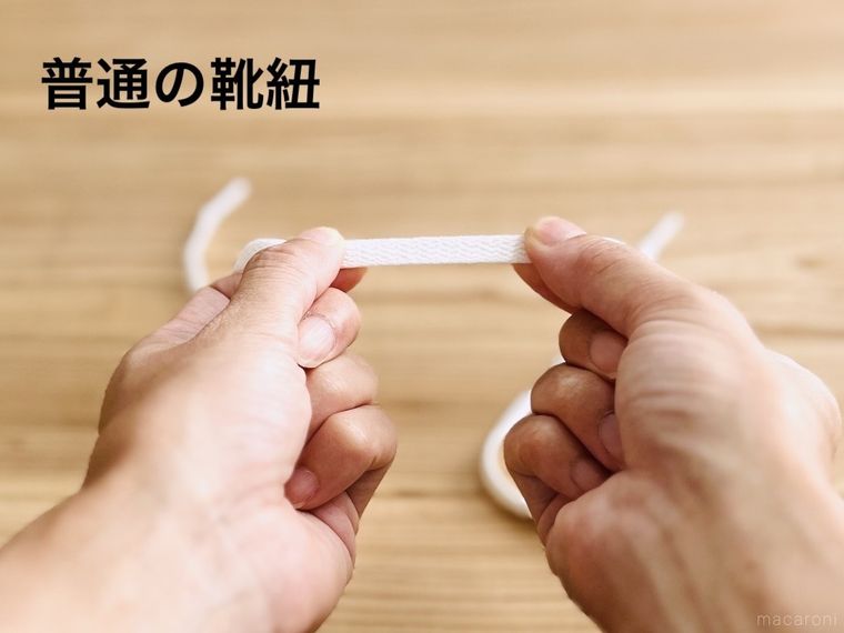 白い靴紐を両手で引っ張っている様子