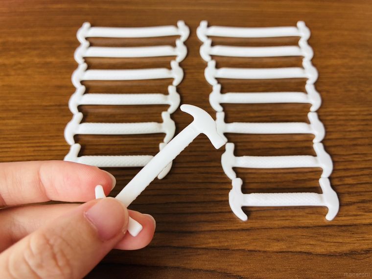 テーブルに並べたシリコーン靴紐と手に持ったパーツ