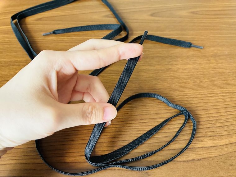 手に持った伸びる靴ひも