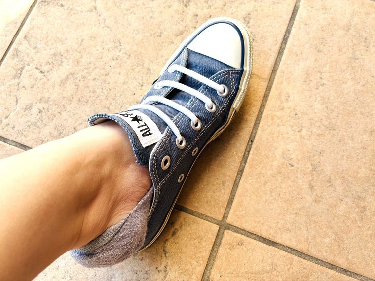 シリコーン靴紐付きのスニーカーを脱いでいる