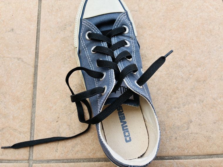 スニーカーの穴すべてに靴紐を通したところ