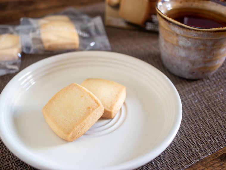 お皿にもったファミリーマート贅沢バタークッキーとカップに入った紅茶がテーブルに並んでいる