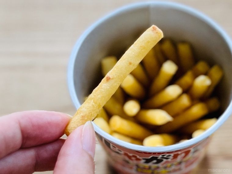 じゃがりこ ベーコンバター醤油味を指でつまんでいる様子