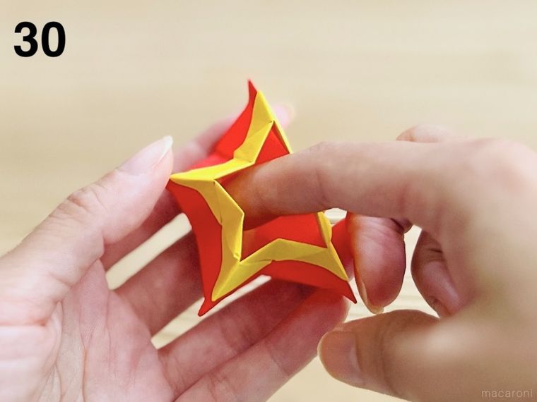 赤い折り紙で星形の小物入れを作っている様子