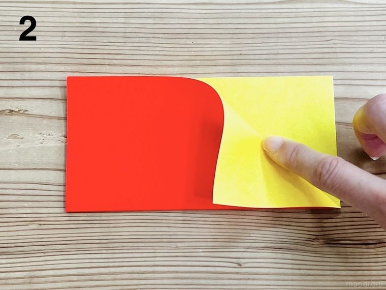 半分に折った折り紙の角を畳んでいる様子