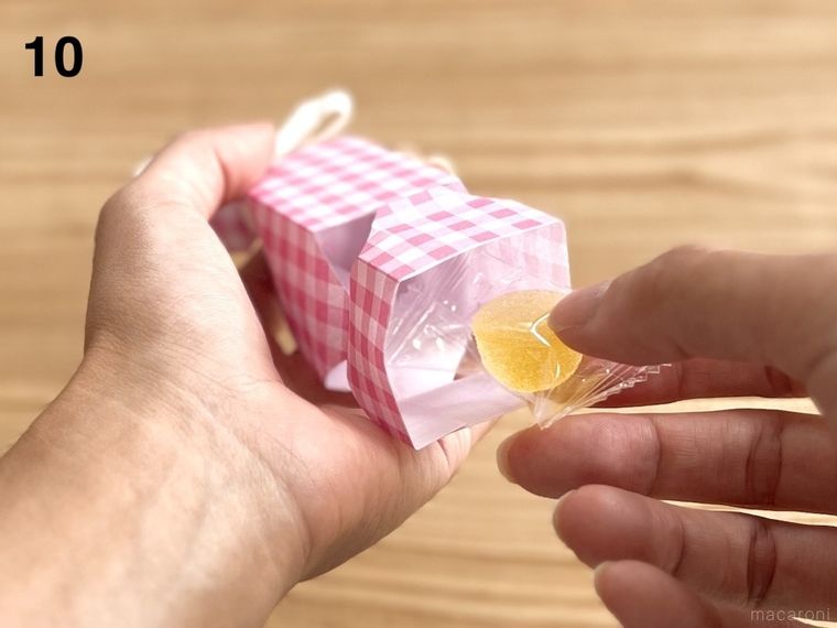 折り紙で作ったキャンディボックスにお菓子を詰めている様子