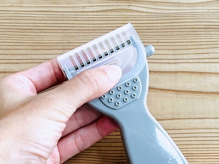 ピーラーに、ダイソーのピーラー用 カバーキャップを取り付けている様子