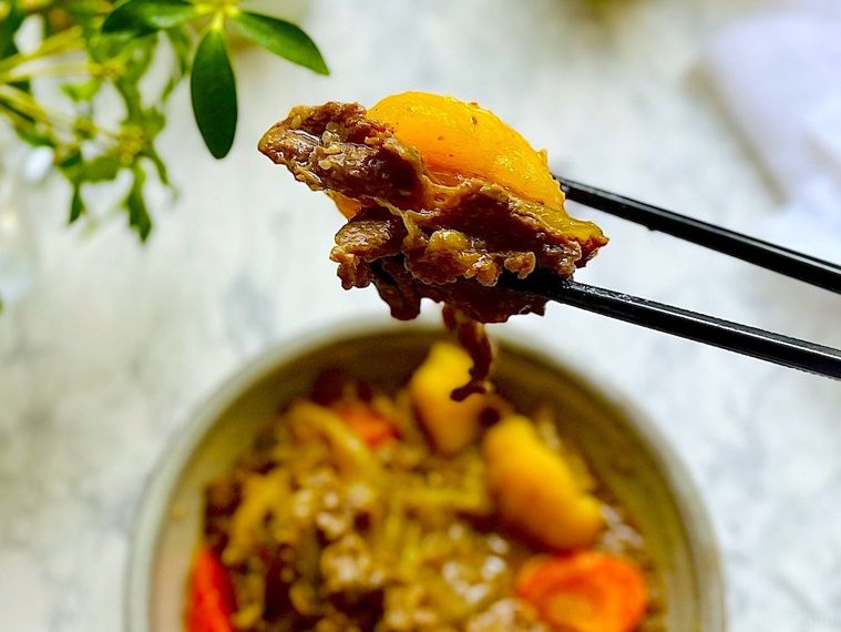 コストコのプルコギで作った肉じゃがをひと口分箸で持ち上げたところ