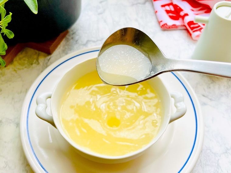 ロティサリーチキンをリメイクして作った鶏がらスープをスプーンですくったところ