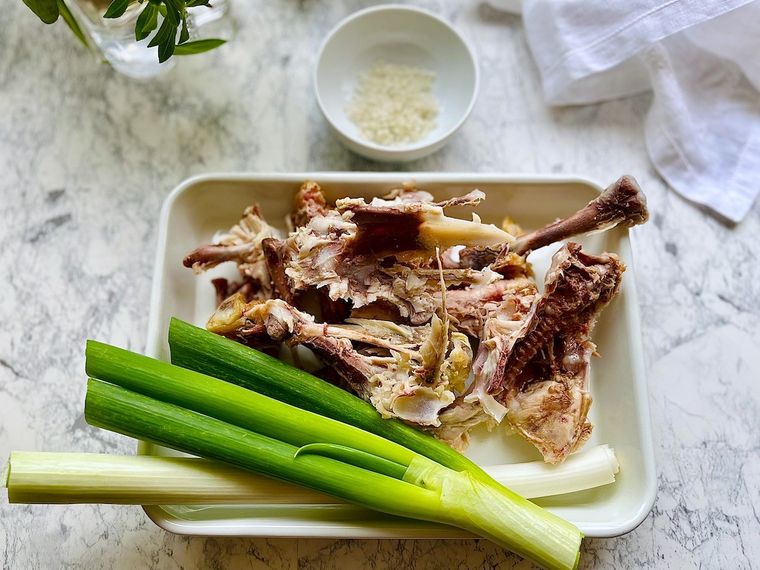 身を外したコストコロティサリーチキンの鶏がらとネギ、小皿に入った岩塩