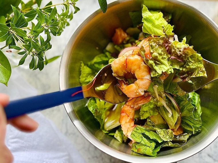 シュリンプサーモンチョレギサラダをボウルに取り出し、ドレッシングを和えているところ