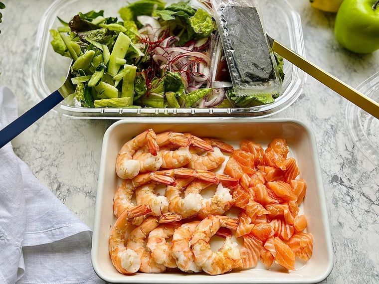 テーブルに並ぶシュリンプサーモンチョレギサラダの具材と野菜