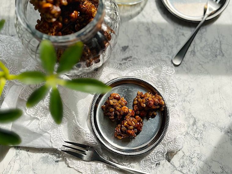 シルバーの小皿に入った3つのもち麦チョコ、ガラスの器、カトラリー