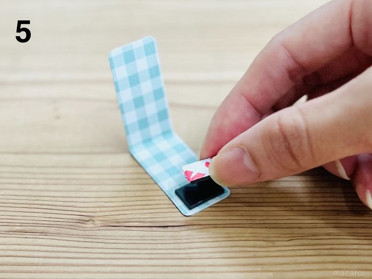 折り紙を貼った厚紙にマグネットをのせている様子