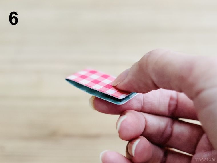 折り紙を貼った厚紙を半分に折っている様子