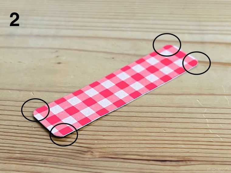 折り紙を貼った厚紙の四隅を丸くカットした様子