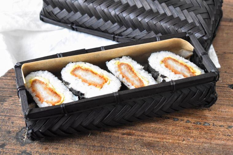 籠の弁当箱に詰めたおにぎらず4個