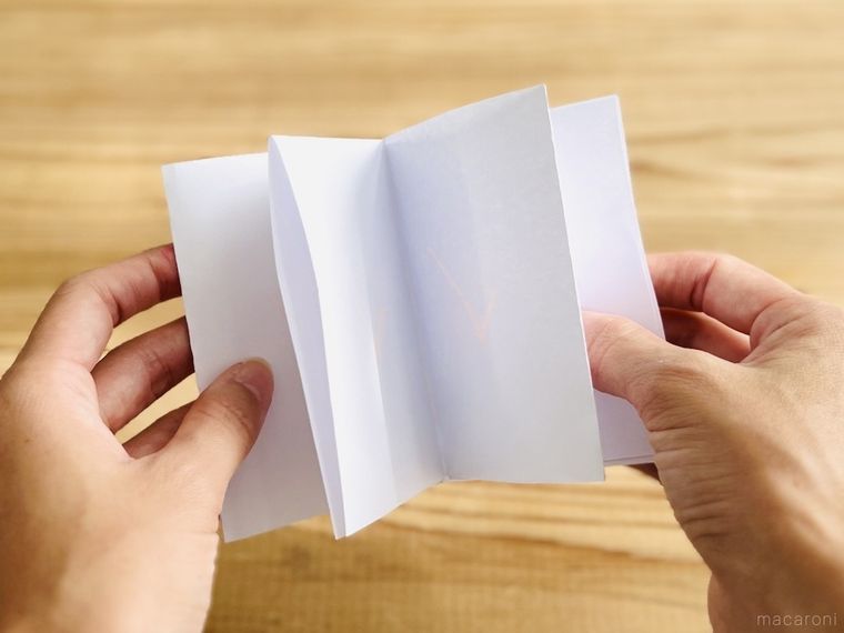 白いノートを手で持っている様子