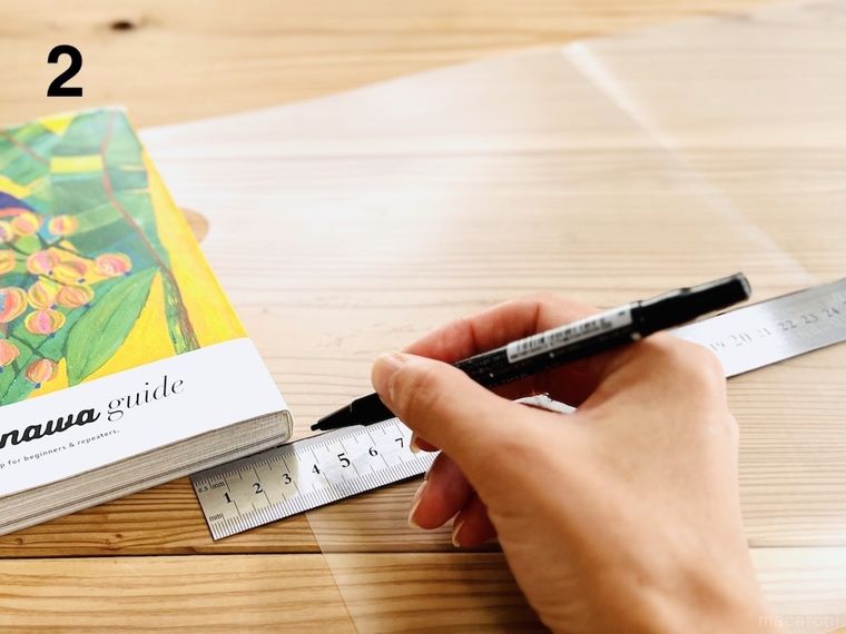 クリアファイルに油性ペンで線を引いている様子