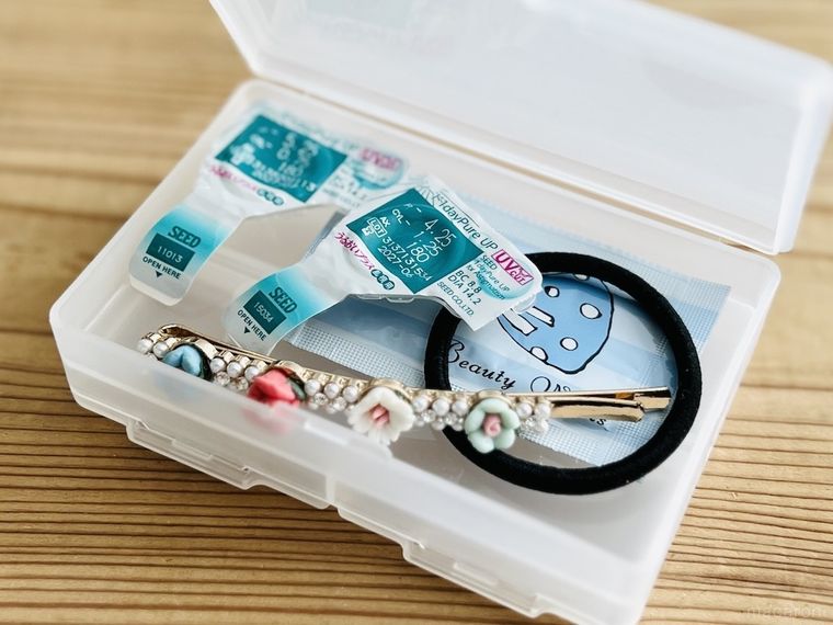 セリアの両面収納小物ケースにコンタクトレンズ、ヘアゴム、ヘアクリップ、サンプルコスメを収納した様子