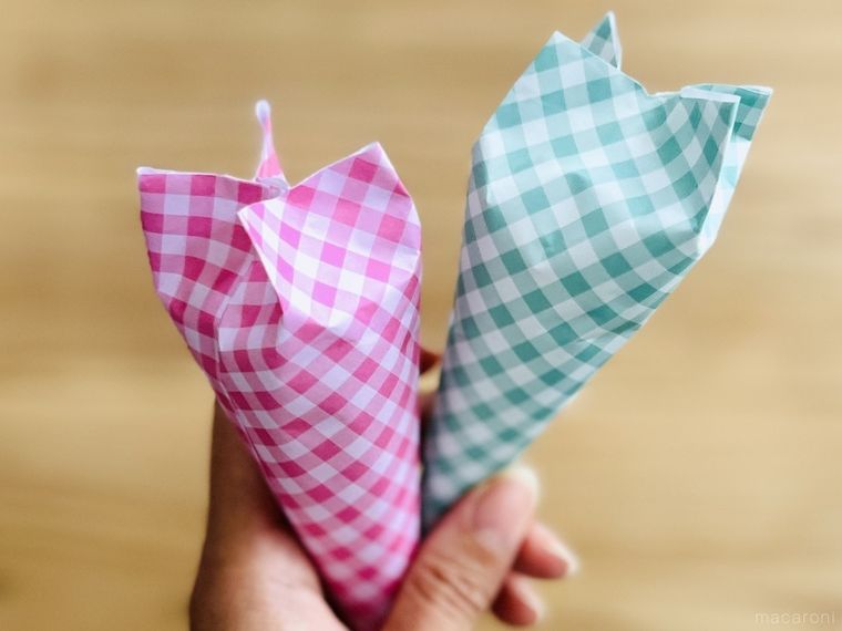 コーン型にラッピングをしたプチギフトを手で持っている様子