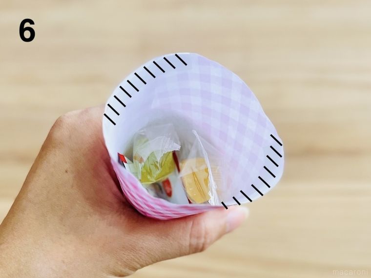コーン型に丸めた折り紙にお菓子を詰めた様子