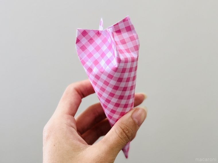 コーン型にラッピングをしたプチギフトを手で持っている様子