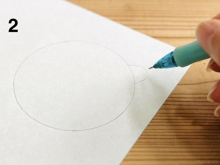 折り紙に書いた円につまみを書き足している様子